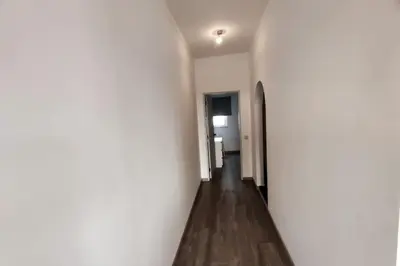 a hallway with white walls and a wooden floor at Sea View Apartment Faro in Faro