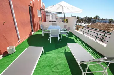 a balcony with a table and chairs and an umbrella at Marimar Sea View Apartment Faro in Faro
