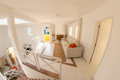 a white living room with a couch and a staircase at Vilamoura Beach Villa with Private Pool in Quarteira