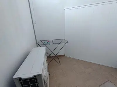 a room with a white wall and a bench and a table at Typical house Faro downtown private entrance in Faro