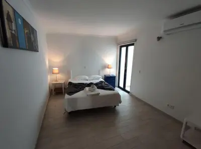 a bedroom with two beds and a hallway with two lamps at Typical house Faro downtown private entrance in Faro