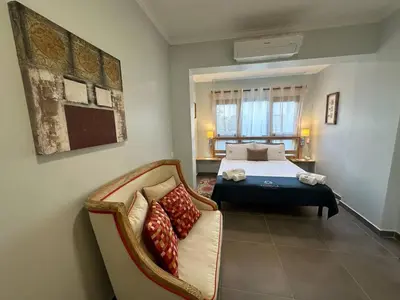 a bedroom with a bed and a couch in it at Carteia Mar by FHR frente Mar & piscina in Quarteira