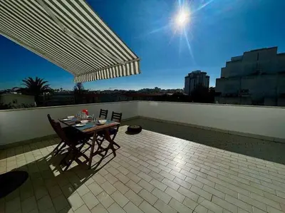 a living room with a couch and a television at Âncora by FHR a 600m da praia in Quarteira