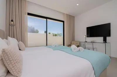 a bedroom with a large bed with a large window at Sirius House in Guia