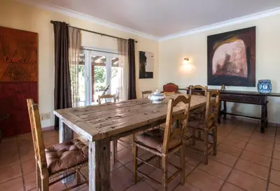 a dining room with a wooden table and chairs at Villa Monte dos Agostos by Boaz Rentals in Santa Bárbara de Nexe