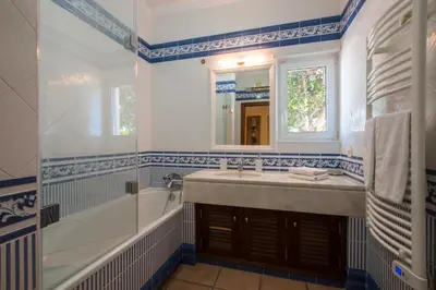 a bathroom with a sink and a tub and a mirror at Villa Monte dos Agostos by Boaz Rentals in Santa Bárbara de Nexe