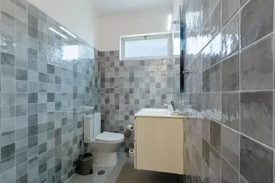a bathroom with a toilet and a sink and a window at Pinhal da Praia by Garvetur in Quarteira