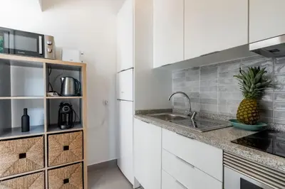 a kitchen with white cabinets and a pineapple on the counter at Pinhal da Praia by Garvetur in Quarteira