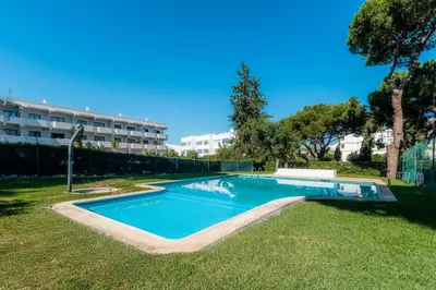 a swimming pool in a yard next to a building at Pinhal da Praia by Garvetur in Quarteira