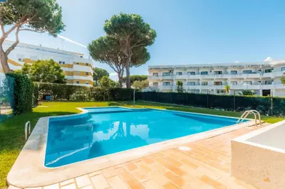 a swimming pool in front of a building at Pinhal da Praia by Garvetur in Quarteira