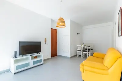 a living room with a yellow chair and a television at Pinhal da Praia by Garvetur in Quarteira