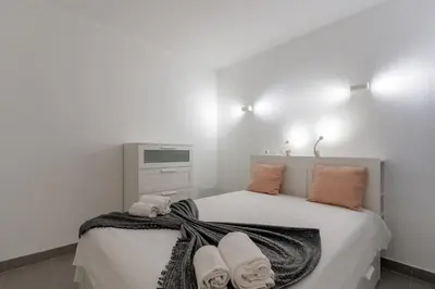 a white bedroom with a bed with towels on it at Pinhal da Praia by Garvetur in Quarteira