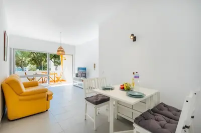 a kitchen and living room with a table and chairs at Pinhal da Praia by Garvetur in Quarteira