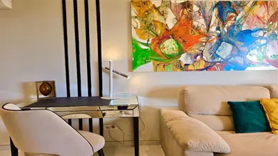 a living room with a couch and a table with a desk at MouraSuites CD 601 - Cleverdetails in Vilamoura