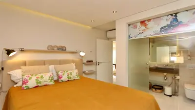 a bedroom with a large orange bed with two pillows at MouraSuites CD 601 - Cleverdetails in Vilamoura