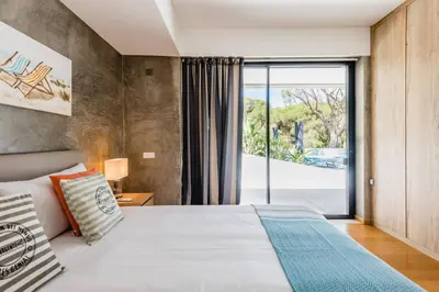 a bedroom with a bed and a sliding glass door at Casa da Alegria, Vale do Lobo in Almancil