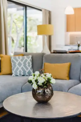 a vase with flowers on a table in a living room at Casa da Alegria, Vale do Lobo in Almancil