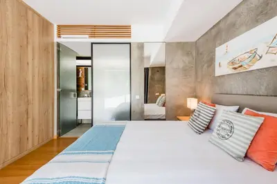 a bedroom with a large bed with orange and blue pillows at Casa da Alegria, Vale do Lobo in Almancil