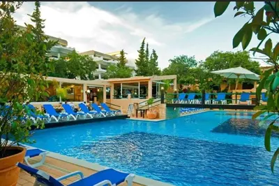 a pool at a resort with blue lounge chairs at Balaia Praia in Albufeira