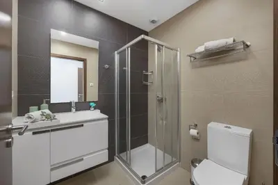 a bathroom with a shower and a toilet and a sink at Areias Branca in Quarteira
