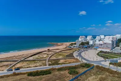 a view of a beach with buildings and the ocean at Areias Branca in Quarteira