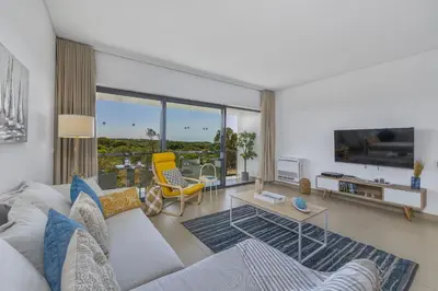 a living room with a couch and a table at Sol e Mar in Quarteira