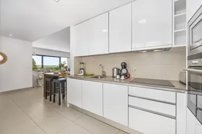 a white kitchen with white cabinets and counters at Vista Mar in Quarteira