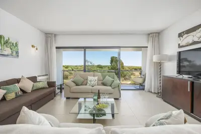 a living room with a couch and a tv at Vista Mar in Quarteira