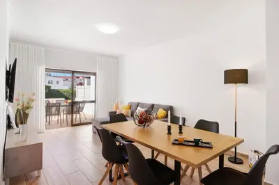 a living room with a wooden table and chairs at Apartment Zeza in Albufeira