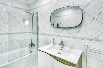 a white bathroom with a sink and a mirror at Villa Garbino in Albufeira