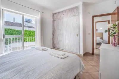 a bedroom with a large bed and a large window at Villa Alecrim in Albufeira
