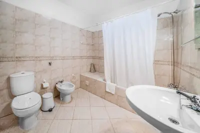 a bathroom with a toilet and a tub and a sink at Villa Alecrim in Albufeira
