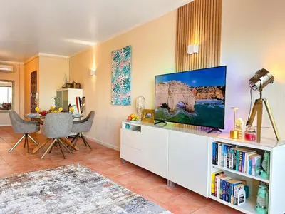 a living room with a tv on a white cabinet at OceanView Apartment by BeCherish in Albufeira