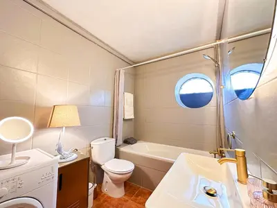 a bathroom with a toilet and a sink and a tub at OceanView Apartment by BeCherish in Albufeira