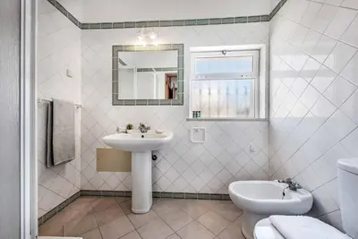 a white bathroom with a sink and a toilet at Villa Oahu in Albufeira