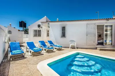 a living room with a bed and a dining room at Villa Oahu in Albufeira