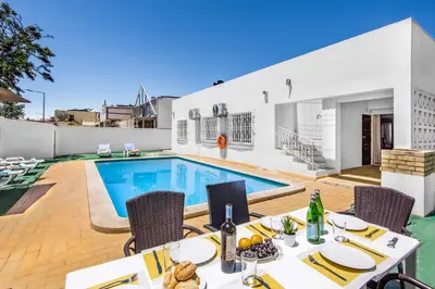 a villa with a swimming pool and a table and chairs at Villa Rum Cay in Albufeira