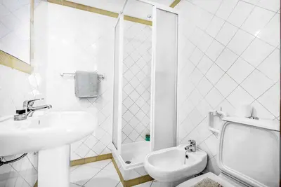 a white bathroom with a sink and a toilet at Villa Rum Cay in Albufeira