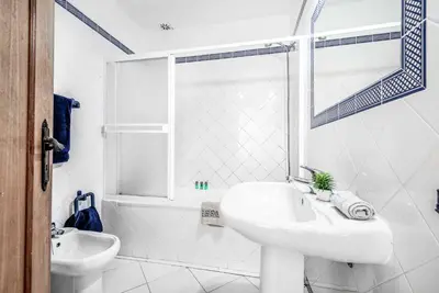 a white bathroom with a sink and a shower at Villa Rum Cay in Albufeira