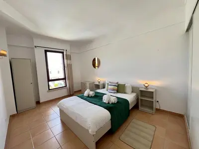 a bedroom with a bed with two towels on it at Albufeira Central 9 by Homing in Albufeira