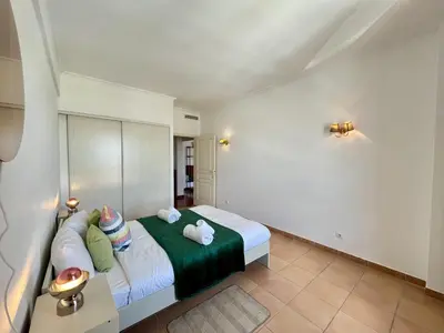 a bedroom with a bed with a green blanket at Albufeira Central 9 by Homing in Albufeira