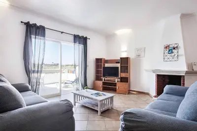 a living room with two couches and a tv at Villa Jasmin Marina in Albufeira