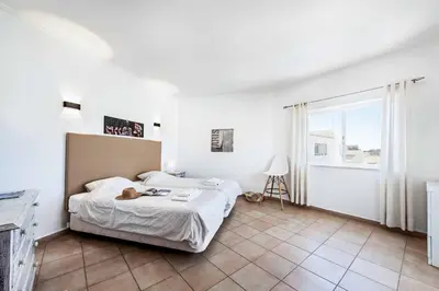 a bedroom with a bed with a cat sitting on it at Villa Jasmin Marina in Albufeira