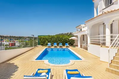 a villa with a swimming pool and some chairs at Villa Jasmin Marina in Albufeira