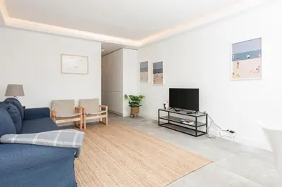 a living room with a blue couch and a tv at BLUE - Vilamoura in Vilamoura
