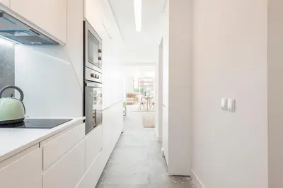a kitchen with white cabinets and a hallway at BLUE - Vilamoura in Vilamoura