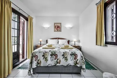 a bedroom with a bed with a floral bedspread at Villa Pardal in Albufeira