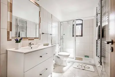 a white bathroom with a toilet and a shower at Villa Pardal in Albufeira