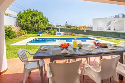 a patio with a table and chairs and a pool at Villa Palawan in Galé