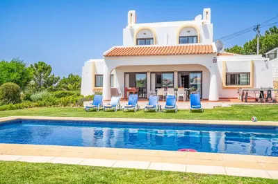 a villa with a swimming pool in front of a house at Villa Palawan in Galé